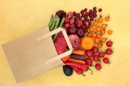 Obst und Gemüse schauen aus liegender Papiertasche heraus